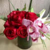 Red roses and pink orchids in a green vase