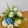 in a glass vase hydrangeas, roses, orchids