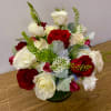 Red and white roses arranged in a low glass vase