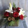Arrangement in a white  ceramic container filled with; red roses, pine