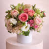 Pink and white floral arrangement in a white vase