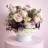 A romantic and elegant floral arrangement bursts with soft, complementary hues of