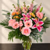 Pink and white mixed flower arrangement in a clear glass vase