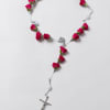 Pink rosebud rosary laid on a white background