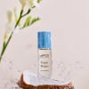Perfume bottle on a coconut half with water splashing around it