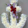 Floral cross arrangement with white flowers, red roses, and lavender blooms