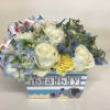 White roses and blue flowers in a baby-themed box with elephant graphics