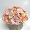 Round bouquet of pastel roses in a textured silver container