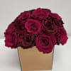 Bouquet of deep pink and burgundy roses in a square gold vase
