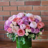 Pink and lavender roses arranged in a glass vase