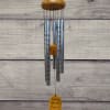 Hanging silver wind chime with a wooden top and yellow accent pieces
