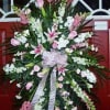 Large pink and white funeral spray with lilies and ribbon