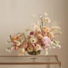 Pastel floral arrangement in a glass pedestal vase