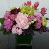 Pink and green mixed flower arrangement in a square glass vase