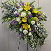 Large standing floral spray with yellow lilies, white roses, and purple flowers