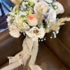 Soft blush and ivory roses mingle with white lisianthus and pale chrysanthemum