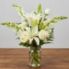 White lilies and roses arranged in a clear glass jar vase