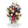 Standing floral spray with red, white, and blue flowers on an easel