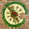 Large floral wreath with white flowers and red roses on a stand