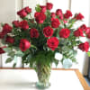 A large bouquet of red roses in a clear glass vase