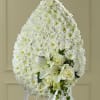 White funeral spray with lilies and roses on an easel
