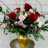 Bouquet of red and pale pink roses in a gold vase