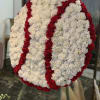 Large circular floral wreath of white and red carnations on an easel