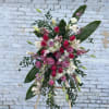 Large standing floral spray with pink and white roses on an easel