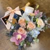 Bouquet with roses, orchids, and a champagne bottle in a gift box