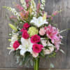 Tall bouquet of pink and white flowers in a glass vase