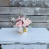 Pink roses arranged in a small geometric vase