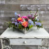 Colorful mixed flower arrangement in a square metal container