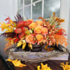 Autumn floral arrangement with orange roses and orchids in a low container