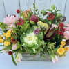 Mixed bouquet with pink and yellow roses in a low wooden container