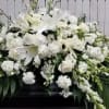 Large white funeral spray with lilies and roses