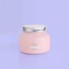 Pink jar candle with a silver lid on a lavender background