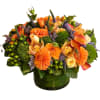 Orange and peach floral arrangement in a green glass vase