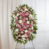 Tall pink and white standing floral spray with lilies, roses, and mums on a metal easel