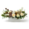 Low arrangement of cream roses with orange accents and seed pods in a white rectangular container