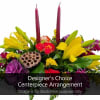 Colorful floral centerpiece with tall candles and a lotus pod