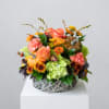Autumn floral arrangement in a woven basket with pumpkins