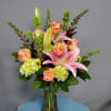 Pink lilies and peach roses in a glass vase