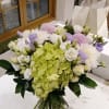 Bouquet of green hydrangea, white roses, and lavender flowers