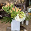 Peach tulips and white hydrangeas in a white vase