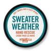 Round tin of hand cream labeled Sweater Weather