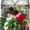 Bouquet of red and pink roses with white orchids in a glass vase