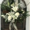 White lilies and roses in a dark vase with a silver ribbon