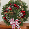 Christmas wreath with pinecones, red ornaments, and a patterned bow