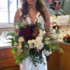 Bride holding a large bouquet of white and burgundy flowers