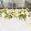Long white floral table arrangement with roses and calla lilies